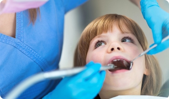 young girl undergoing dental exam from professional looking at teeth with mirror
