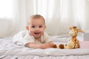 Adorable laugh with 2 teeth smile a baby takes a toy giraffes and learns to crawl