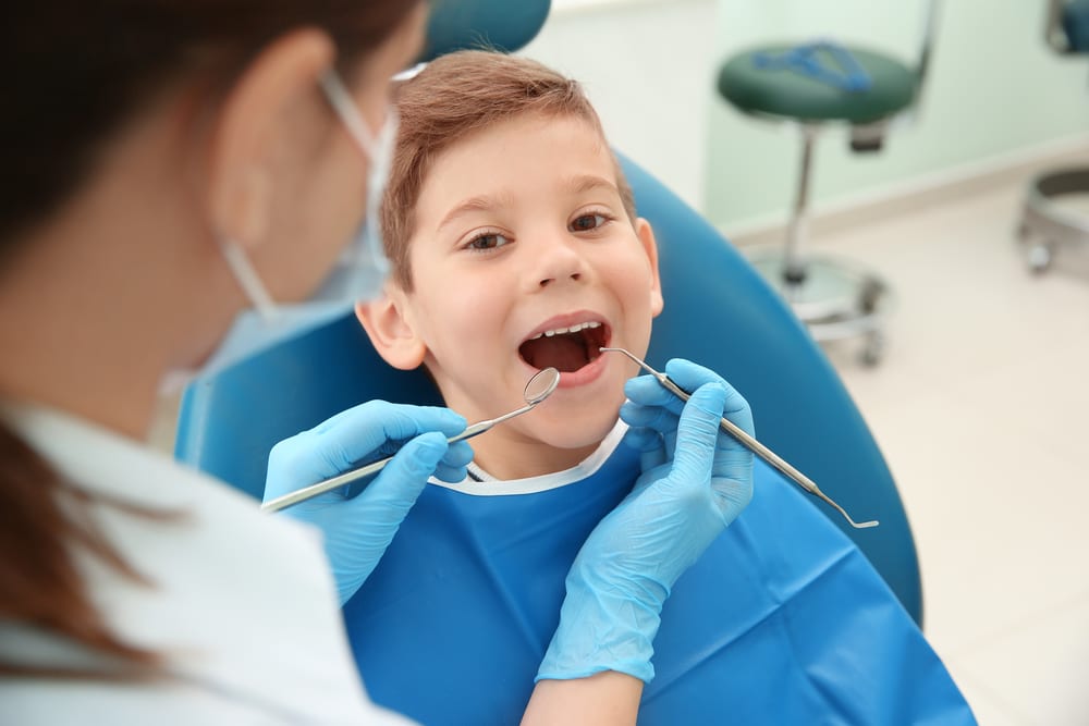 Dentist,Examining,Little,Boy's,Teeth,In,Clinic Dentist,Examining,Little,Boy's,Teeth,In,Clinic